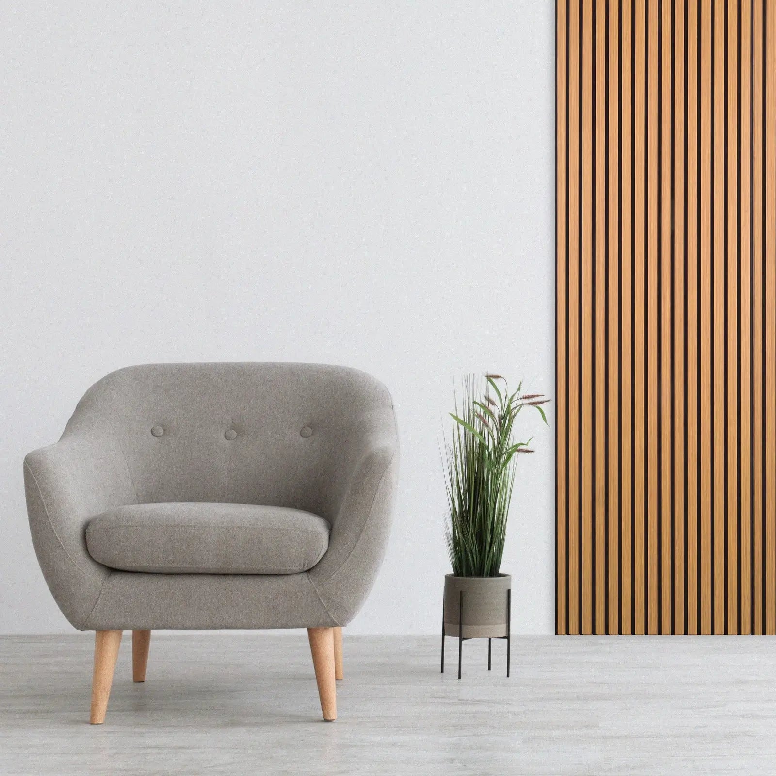 Gray upholstered armchair next to Acoustic Slat Wood Wall Panel in Oak finish