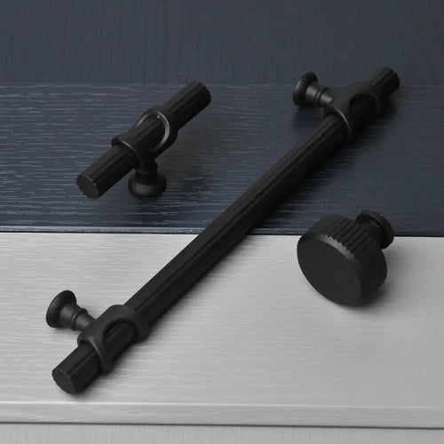 Black metal door pull handle with decorative knobs on each end.