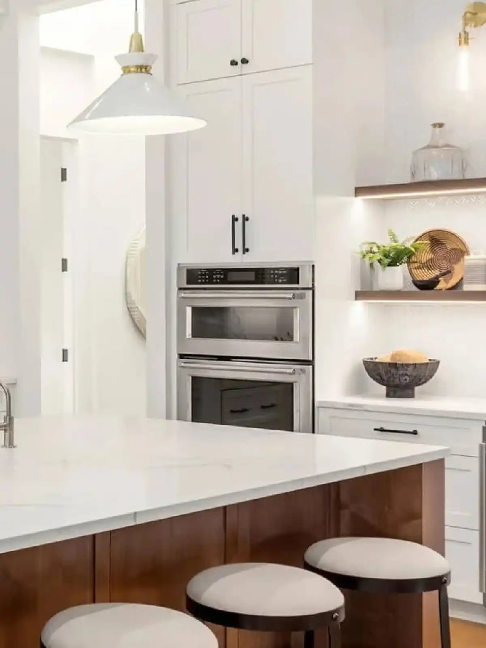 Modern white kitchen island with wooden base and bar seating.