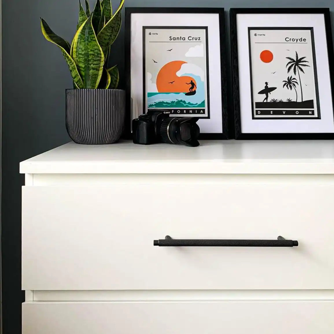 White dresser with a black horizontal handle.